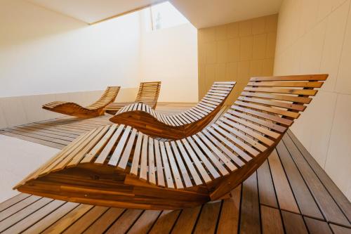 a wooden bench with two chairs on a floor at Ferienapartments Müller in Ebene Reichenau