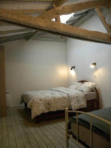 1 Schlafzimmer mit 2 Betten und Holzboden in der Unterkunft le Domaine des Sauvineries in Saint-Germain-de-Prinçay