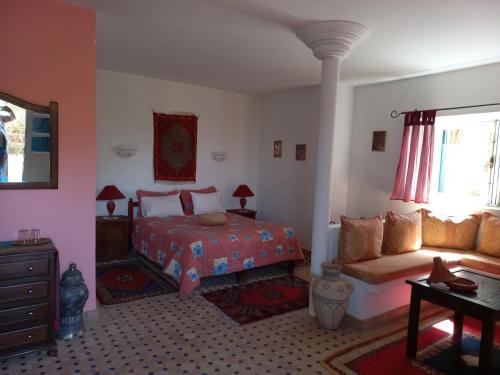 1 dormitorio con cama y sofá en Les Tourmalines, en Ouarzazate
