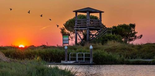 a building on the shore of a body of water with the sunset at Alloggio turistico a Ravenna in Ravenna