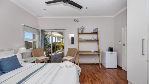 1 dormitorio con 1 cama, mesa y sillas en Anchor Bay Workation, en Ciudad del Cabo