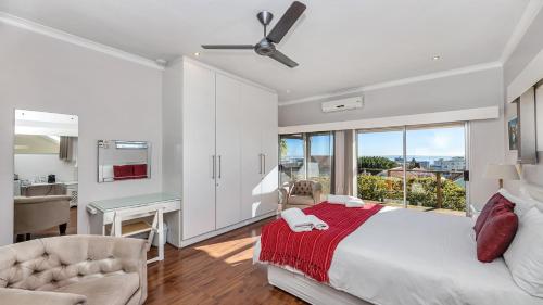a bedroom with a bed and a large window at Anchor Bay Workation in Cape Town