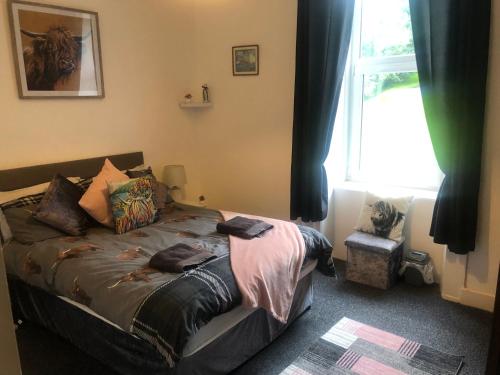 a bedroom with a bed with a window and a window at Captivating 2-Bed Apartment in Isle of Bute in Rothesay