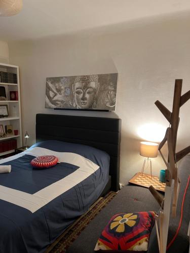 een slaapkamer met een bed met een standbeeld aan de muur bij Lit Queen Size, 3mn Beach Biarritz in Biarritz