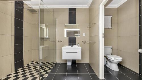 a bathroom with a toilet and a sink and a shower at Anchor Bay Workation in Cape Town