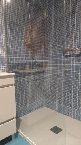 y baño con ducha de azulejos azules. en Casa da Encosta, en Ericeira
