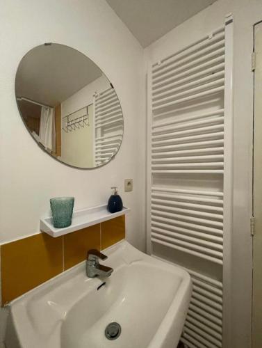a white bathroom with a sink and a mirror at Studio tendance Charleroi centre in Charleroi