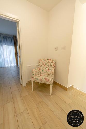 a room with a chair with a flower pattern on it at Mi Casa 2 in Vrdnik