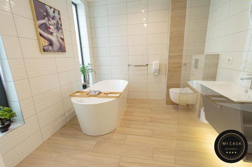 a white bathroom with a tub and a toilet at Mi Casa 2 in Vrdnik