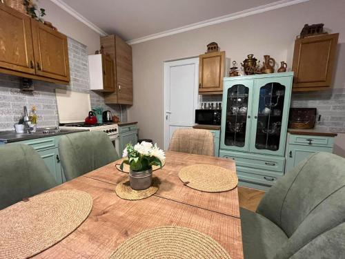 a kitchen with a wooden table with green chairs at Happy Holidays in Borjomi
