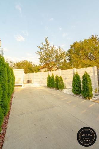 a driveway with a white fence and some trees at Mi Casa 2 in Vrdnik