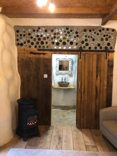 an open door to a room with a stove at Rabbits 1or 2 bedroom hobbit style hillset earthen dartmoor eco home in South Brent