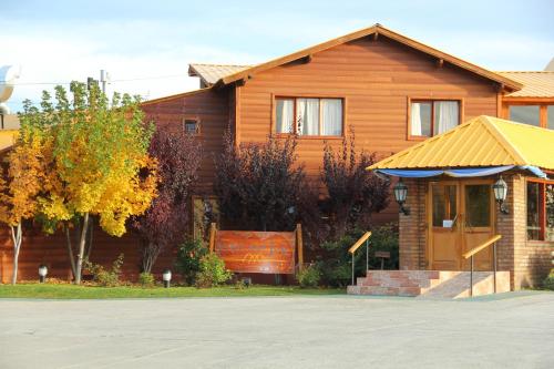 a wooden house with a sign in front of it at Hotel Picos Del Sur in El Calafate