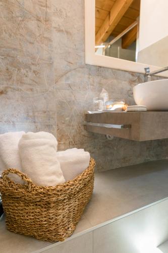 a bathroom with a basket of towels and a sink at Charming Sirmione in Sirmione