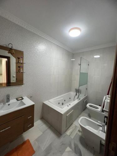 uma casa de banho com uma banheira, um lavatório e um WC. em Recidence montblanc Tanger em Tânger