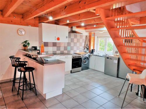 une cuisine avec des placards blancs et un escalier dans l'établissement La ferme de Georges Apt 1 à 6 pers, à Bischholtz