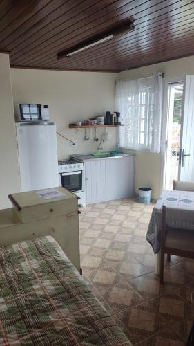 a kitchen with a refrigerator and a table in a room at Vilarejo da Esperanza in Campos do Jordão