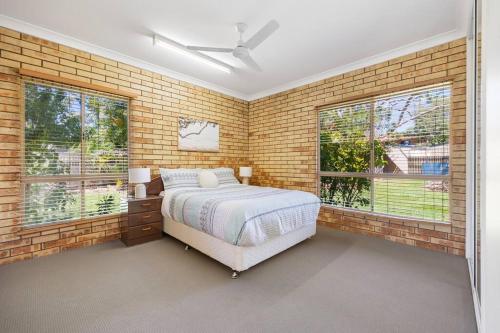 a bedroom with a bed in a brick wall at 5 bedrooms with a pool in Kawungan