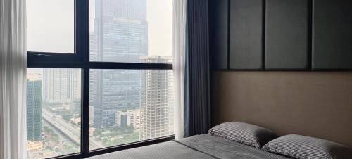 une chambre avec un lit et une grande fenêtre dans l'établissement Vinhomes West Point, à Hanoï