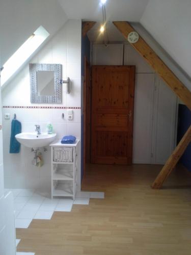 a bathroom with a sink and a wooden door at Ferienwohnung Stablo in Kommen