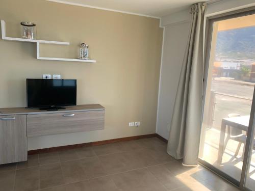 a living room with a television and a window at Lazareto Oceanview in Mindelo