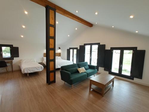 a living room with a green couch and a bed at CASA LA GRANJA in Galizano