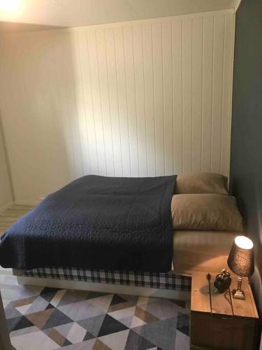 ein Schlafzimmer mit einem Bett und einer Lampe auf einem Tisch in der Unterkunft Leilighet i Vadsø in Vadsø