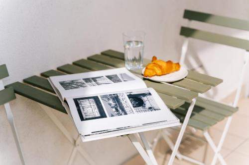 a table with a book and a plate with a glass at Żoliborz Business Apartments by Rentujemy in Warsaw
