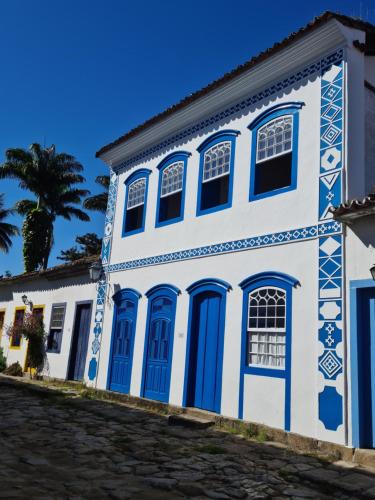 un edificio azul y blanco con toques azules en Flor de Lis Chalés en Parati