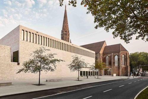 a large brick church with a steeple on a street at Suburban Jungle in Bochum