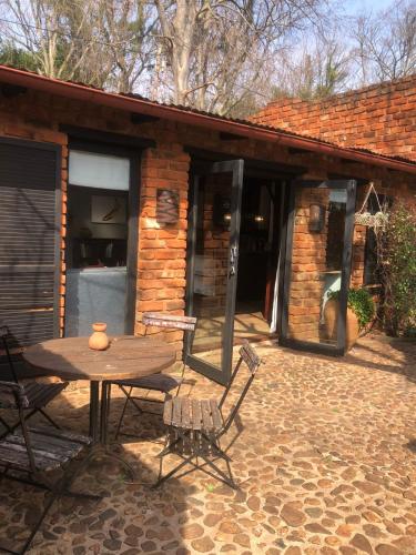 a patio with a table and chairs in front of a building at Mill Lane Farmhouse in Hartbeespoort