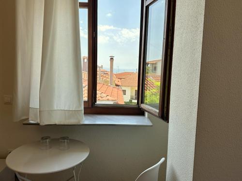 una finestra in una stanza con tavolo e lavandino di 7PocketHouse a Salonicco