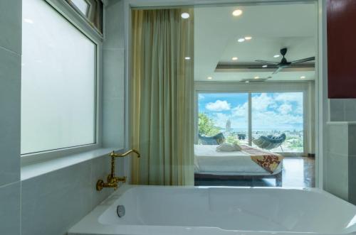 e bagno con finestra e vasca. di seaview patong private pool sauna 4br villa a Patong Beach