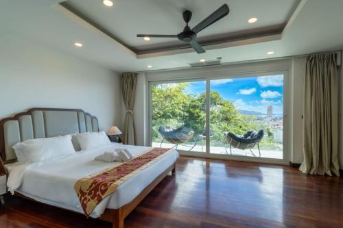 una camera con un letto e una grande finestra di seaview patong private pool sauna 4br villa a Patong Beach