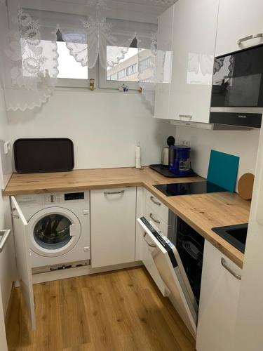 a small kitchen with a washing machine in it at Marl Central Apartment in Marl
