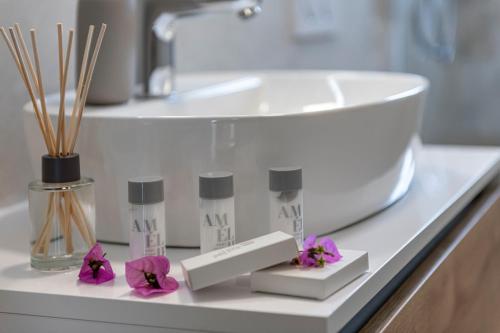 a bathroom counter with a sink and some purple flowers at Apartment Meri in Dubrovnik