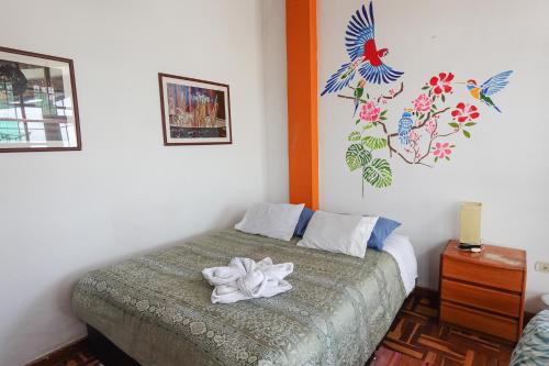 Un dormitorio con una cama con una flor. en Native Soul Guesthouse en Cuzco