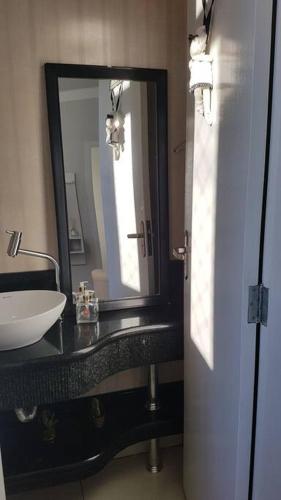 a bathroom with a sink and a mirror at Apartamento com 3 quartos! 7 camas no Centro in Lages