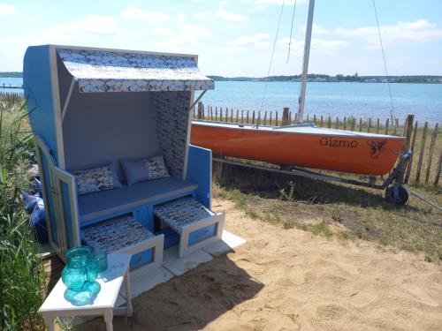 a small toy house with a boat in the background at Strandhaus "Knuffeltje" in Rötha