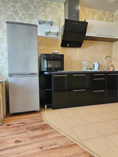 uma cozinha com um frigorífico e um micro-ondas em Most City Riverview em Dnipro