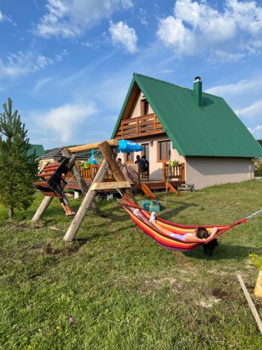 Un homme se posant dans un hamac devant une maison dans l'établissement Planinska kuca, à Žabljak