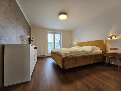 een slaapkamer met een bed, een dressoir en een raam bij Apartmán U Labe in Nymburk