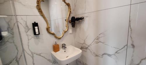 a white bathroom with a sink and a shower at XuBa ApartmentRooms Messe Wien Prater in Vienna