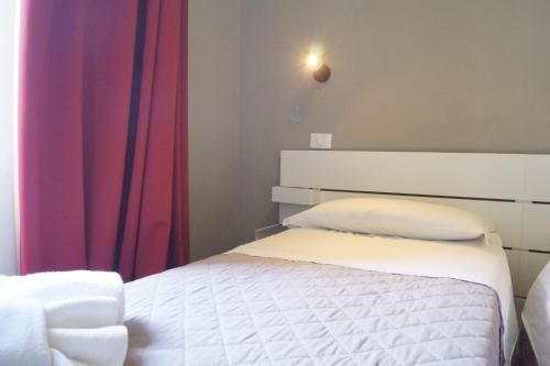 a bedroom with a bed and a red curtain at Hotel Alabama by ALEhotels in Rimini