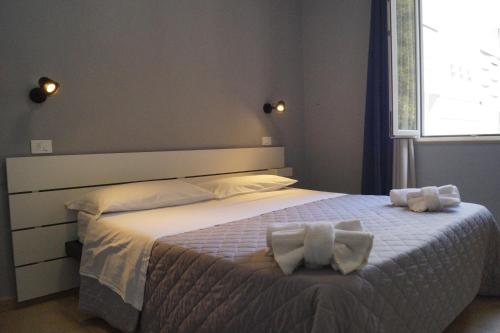 a bedroom with a bed with two towels on it at Hotel Alabama by ALEhotels in Rimini