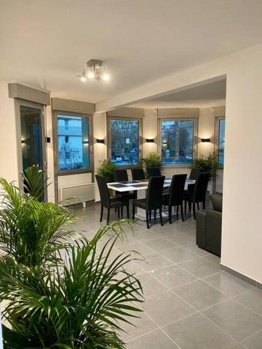 une salle à manger avec une table, des chaises et des fenêtres dans l'établissement Appartement 125m2 au centre de Cusset, à Cusset