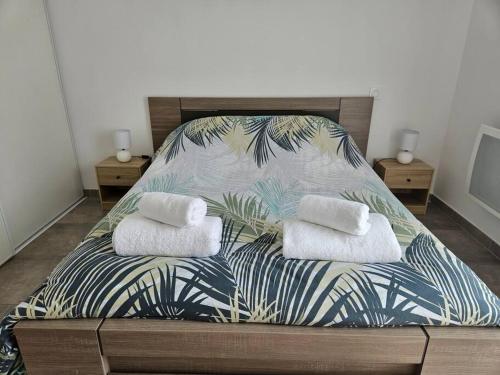 ein Bett mit zwei Kissen auf einem Zimmer in der Unterkunft Appartement neuf, rez-de-jardin in Lucciana