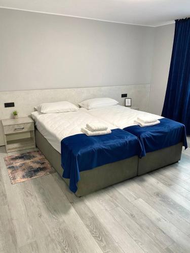 a bedroom with a large bed with a blue blanket at готель Вікторія in Volovets