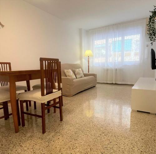 ein Wohnzimmer mit einem Tisch, Stühlen und einem Sofa in der Unterkunft Sueños de Mar in Pineda de Mar