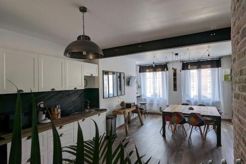 una cucina e una sala da pranzo con tavolo e sedie di Chez Pépère a Londinières